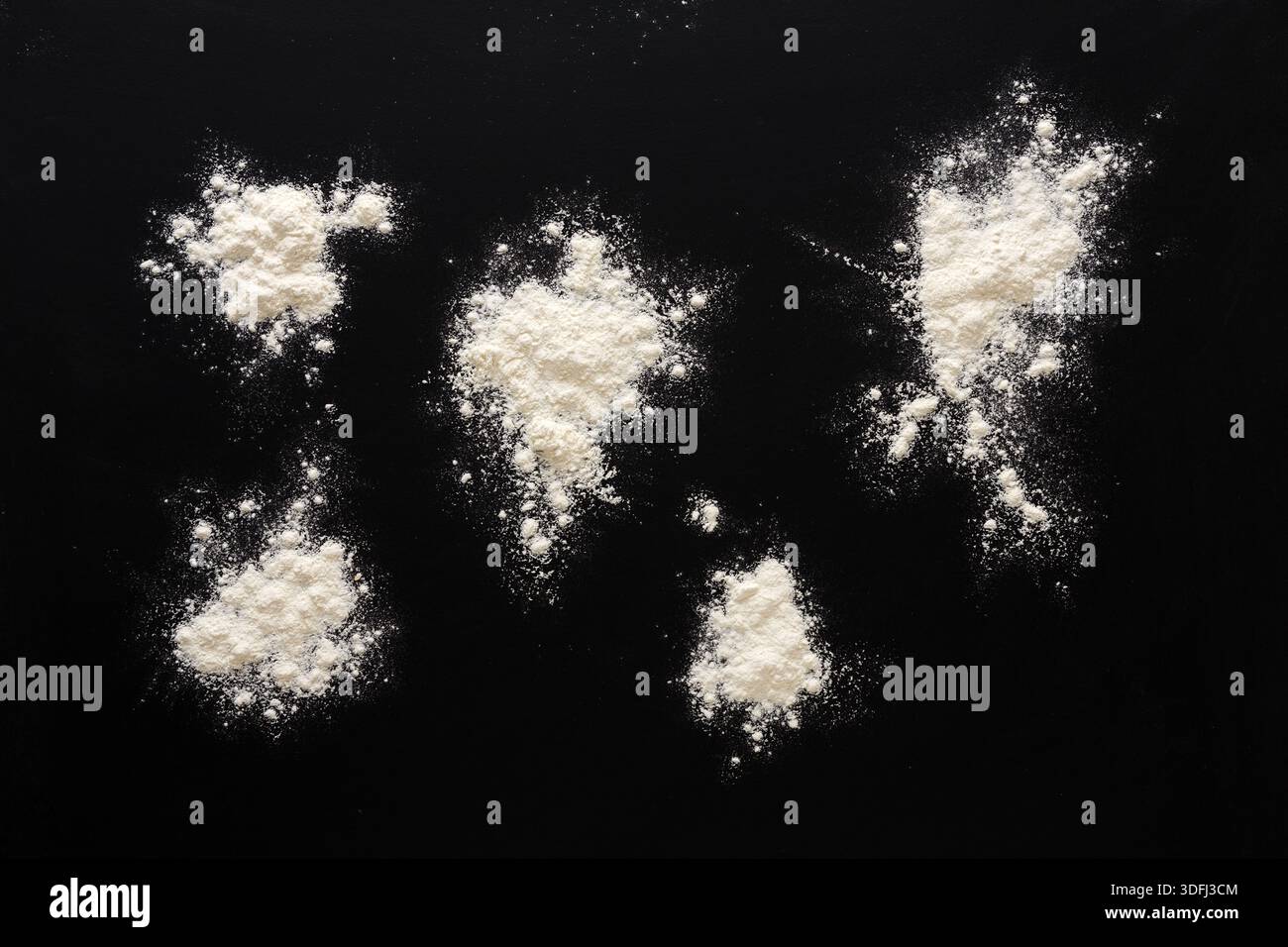 Sprinkled wheat flour splash spots on black background Stock Photo