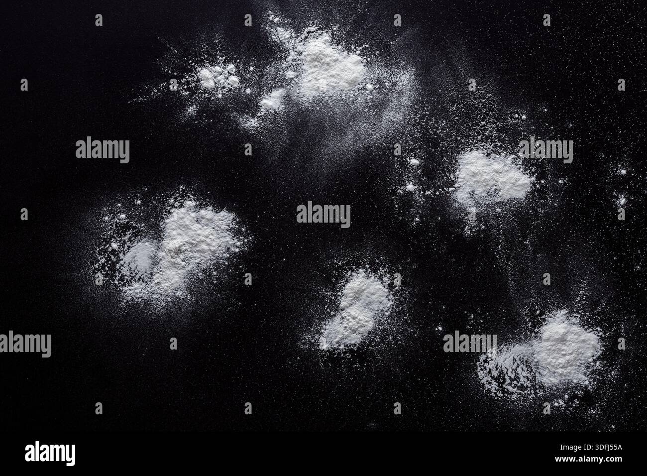 Sprinkled wheat flour splash spots on black background Stock Photo