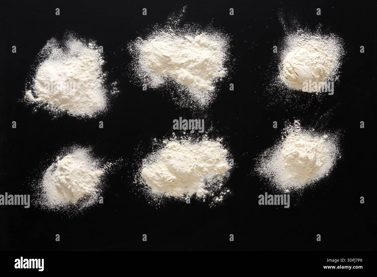 Sprinkled wheat flour splash spots on black background Stock Photo
