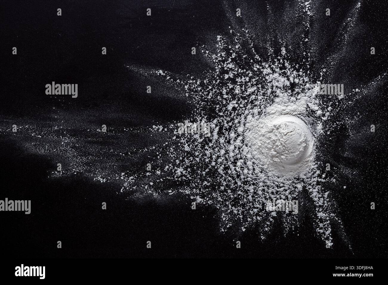 Sprinkled wheat flour splash spots on black background Stock Photo