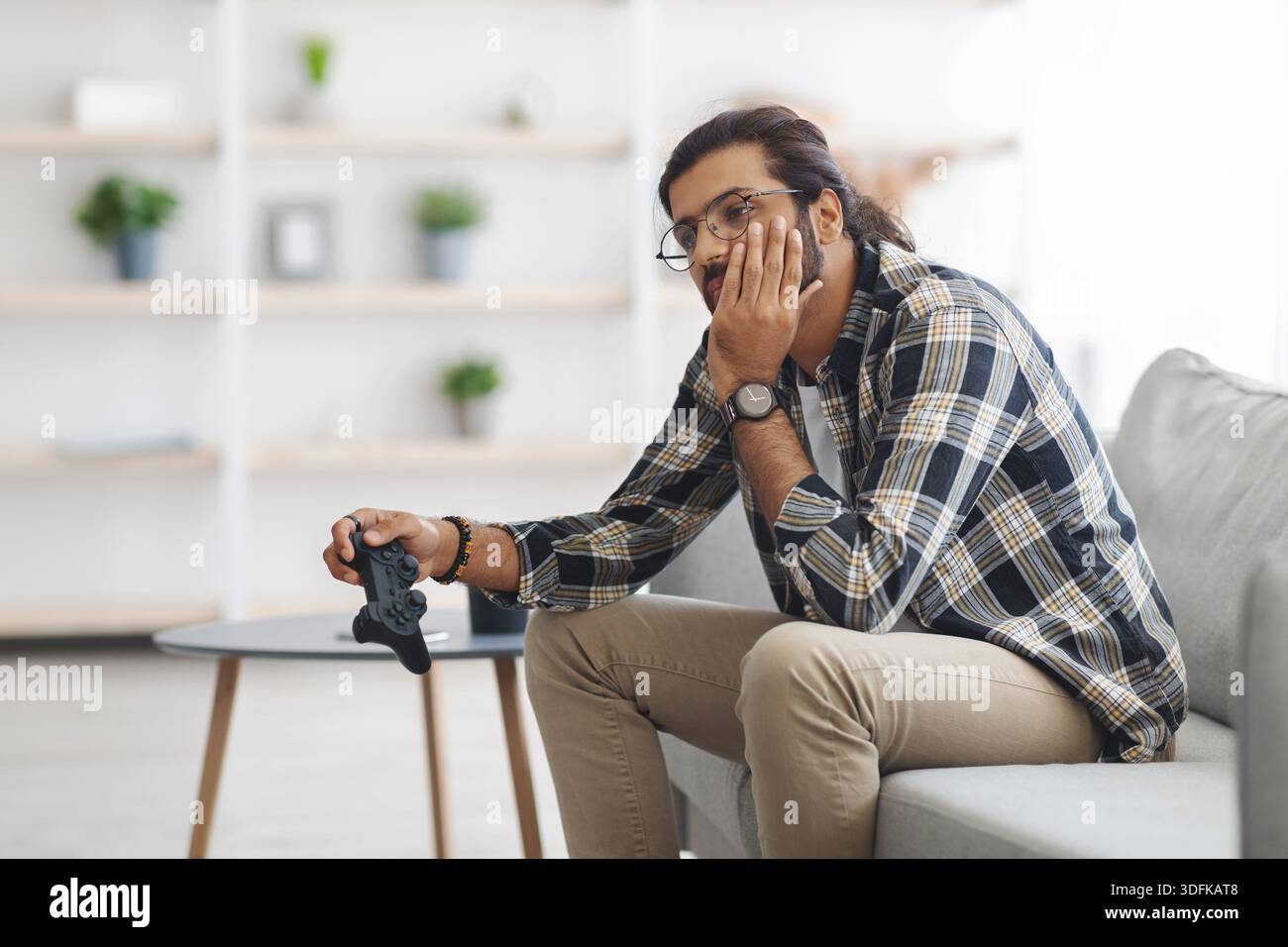 Upset middle-eastern guy got bored while playing video games Stock Photo