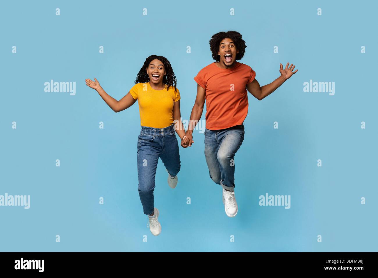 Excited african american lovers holding hands while running Stock Photo