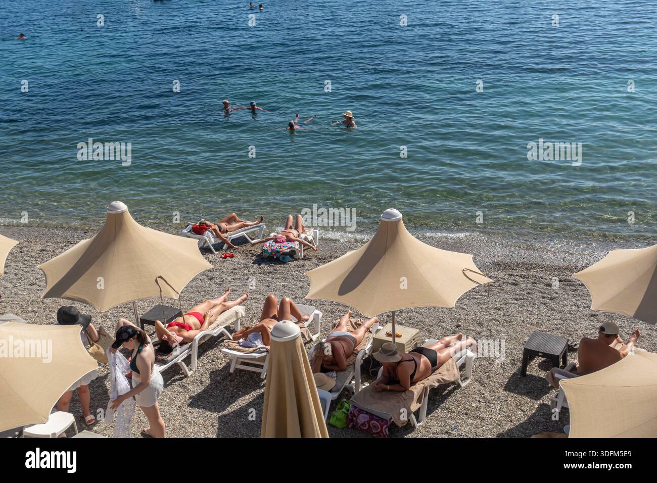 People sunbathing at Kumbahce Belediye Plajı, Municipality Beach in Bodrum, Turkey Stock Photo