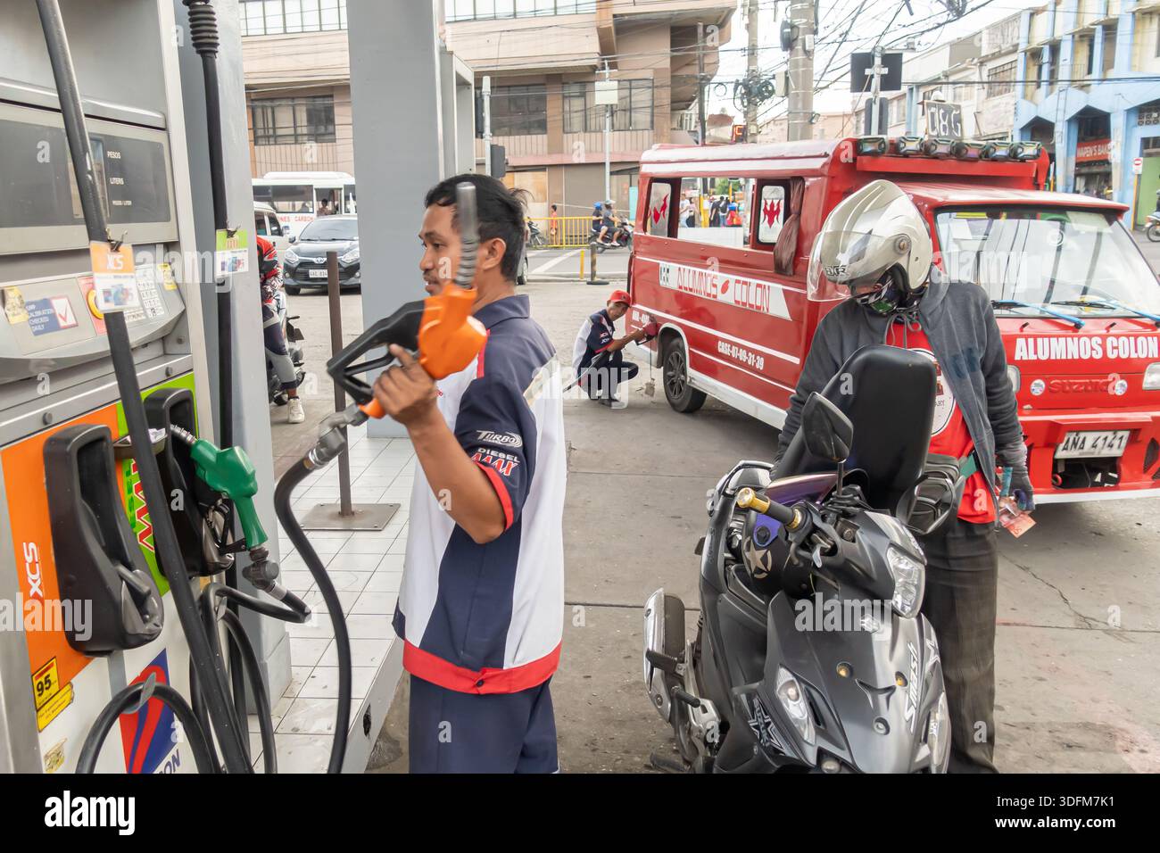Gas station workers refuel motorcycle at a station in Cebu, Philippines Stock Photo
