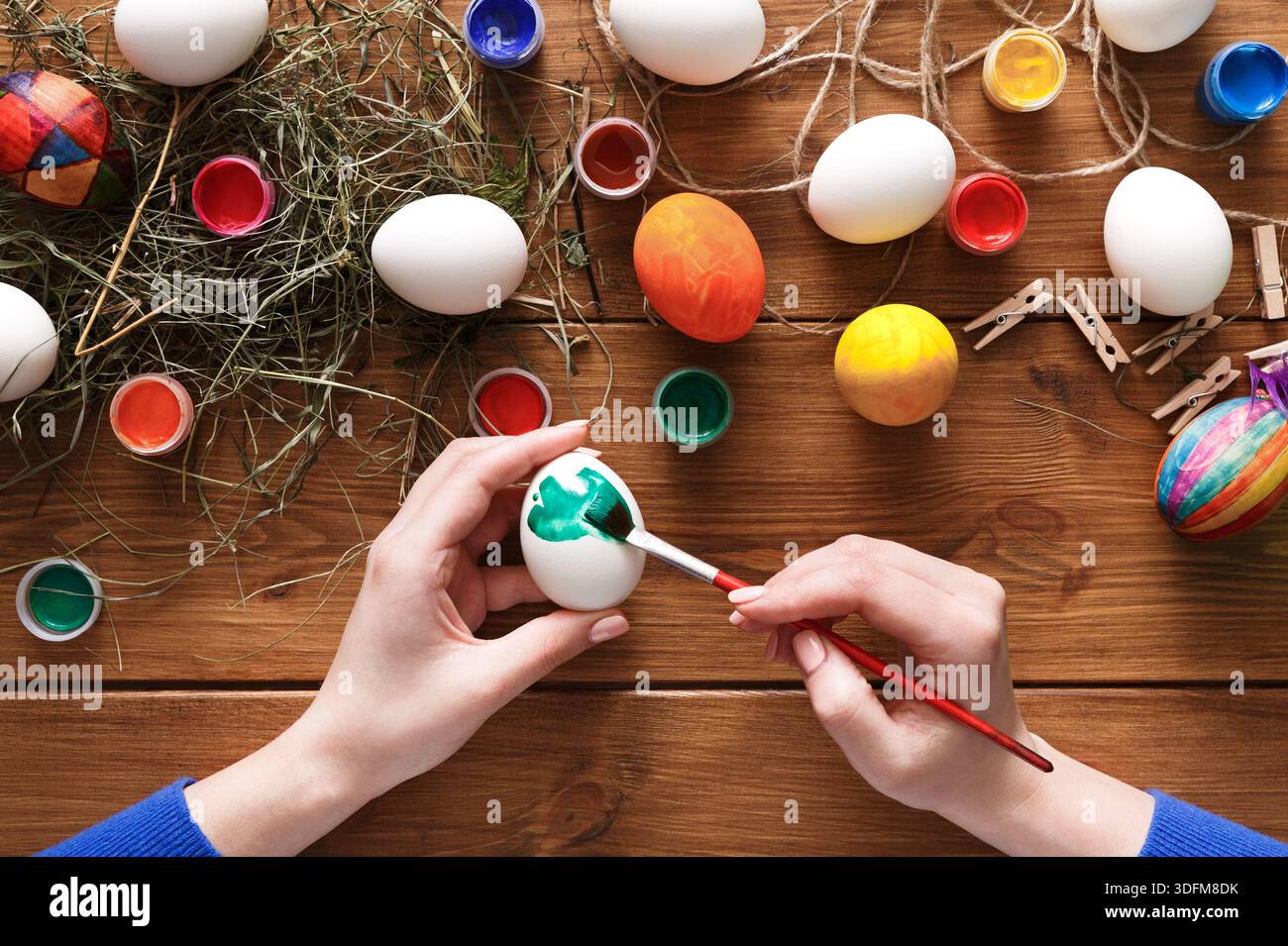 Creative Easter Egg Decorating Activity With Paint and Colors on a Wooden Table Stock Photo
