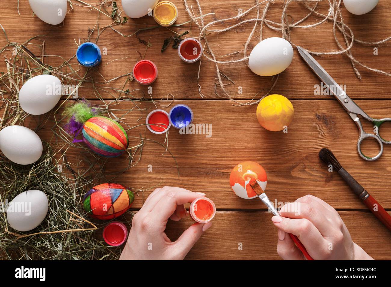Creative Easter Egg Decoration Activity With Paints and Tools on Wooden Table Stock Photo