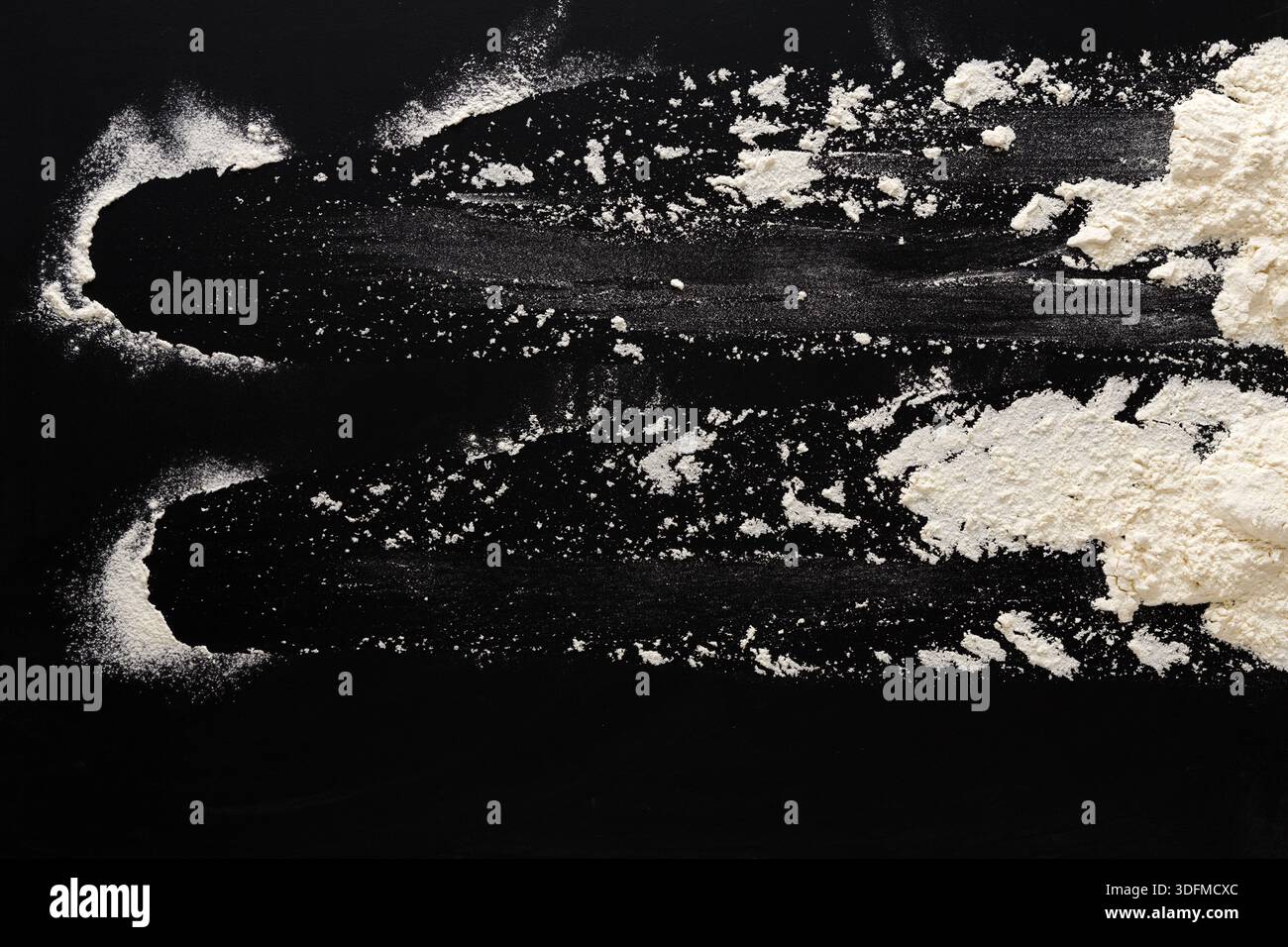 Sprinkled wheat flour splash spots on black background Stock Photo