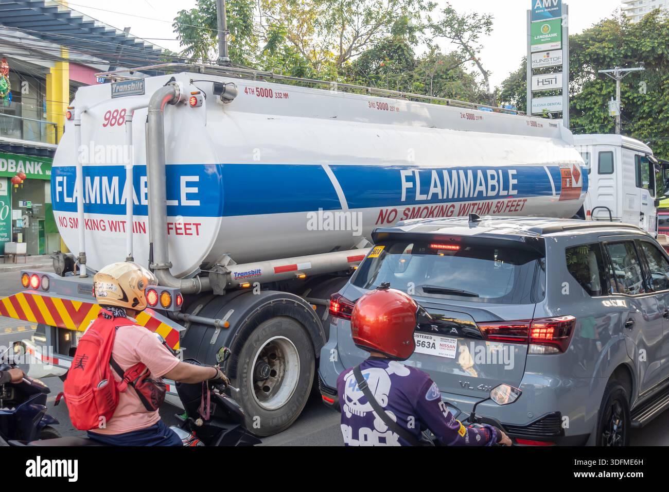 a tanker truck transporting flammable material in traffic in an urban area with Flammable and No smoking within 50 feet warnings, Cebu, Philippines Stock Photo