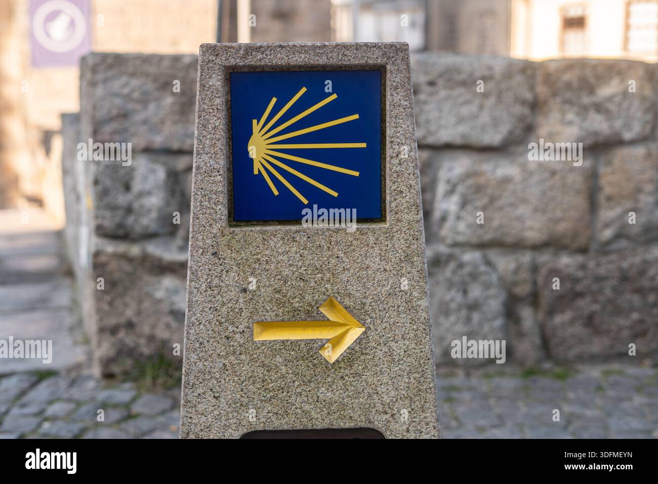 Camino milestone with road sign: The scallop shell and yellow arrow are ...