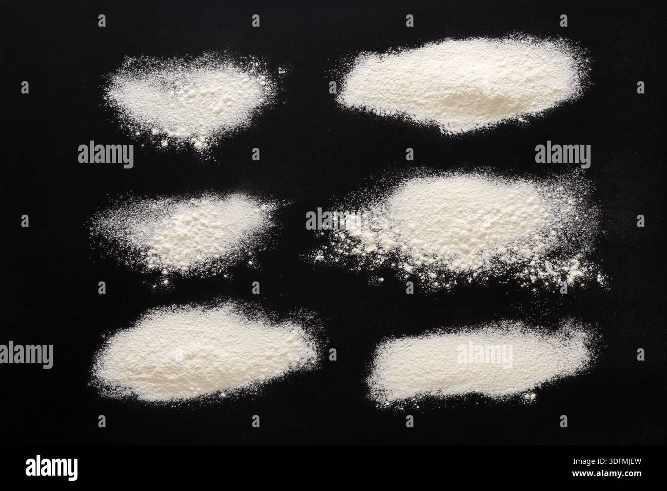 Sprinkled wheat flour splash spots on black background Stock Photo