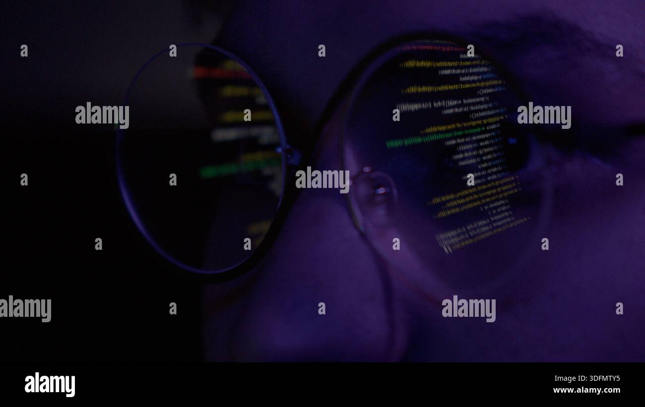 Programmer looking at code through glasses Stock Photo