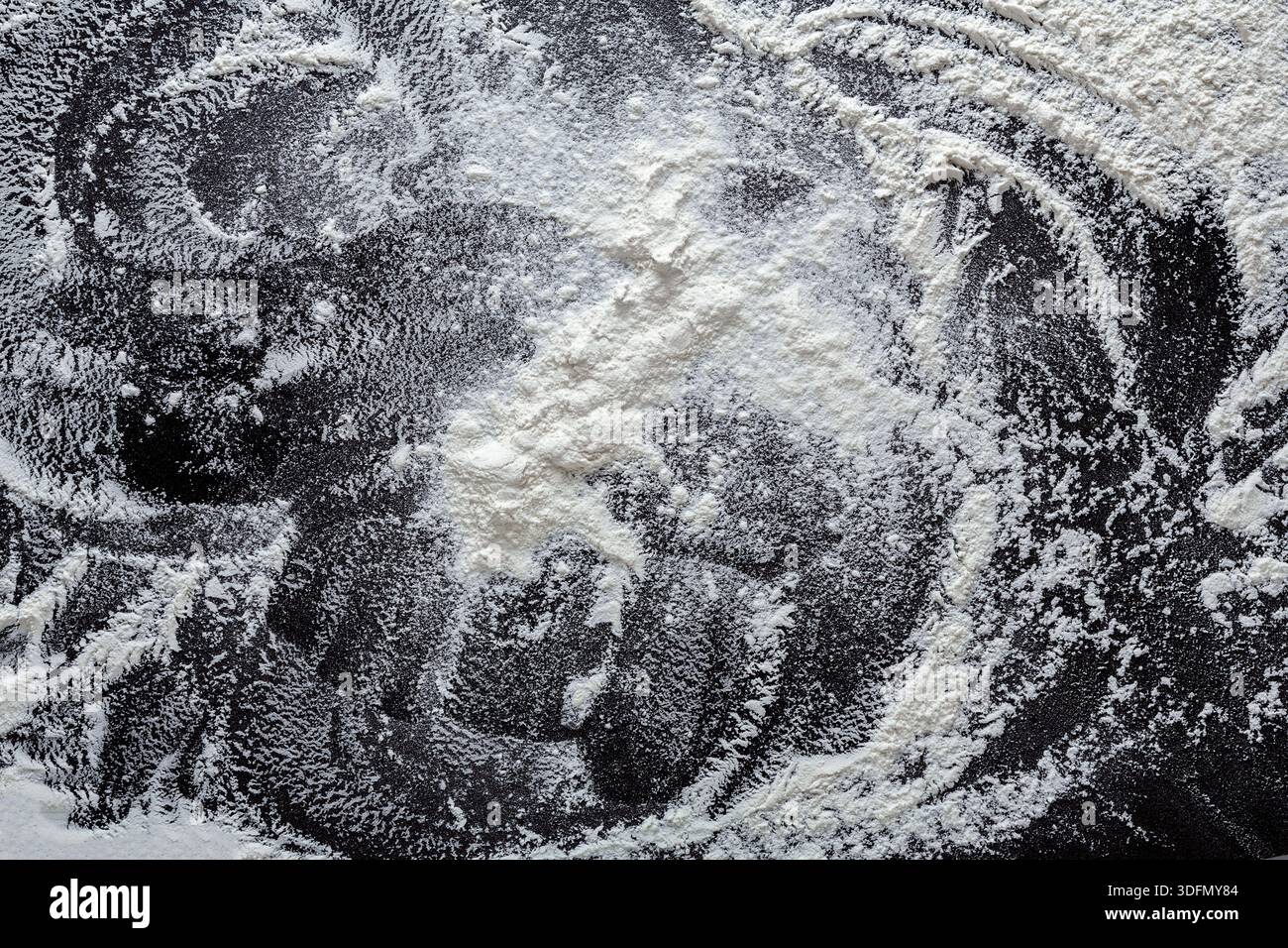 Flour Scattered Artfully on a Dark Kitchen Surface Creating Unique Patterns and Textures Stock Photo
