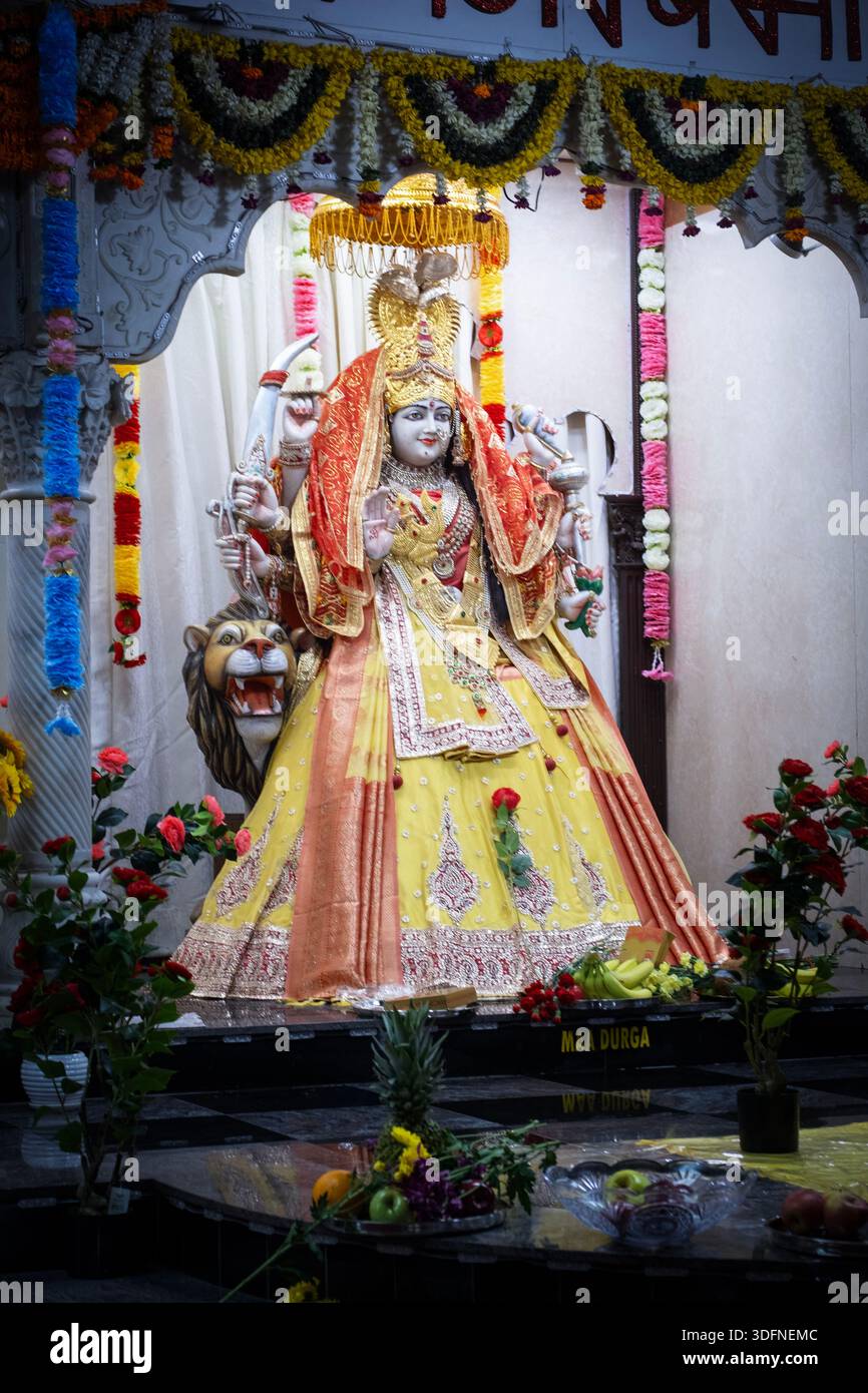 A statue of the Hindu goddess Durga depicted with several arms and near a lion. At the Geeta Temple Ashram on 56th St. in Woodside, Queens, NY. Stock Photo