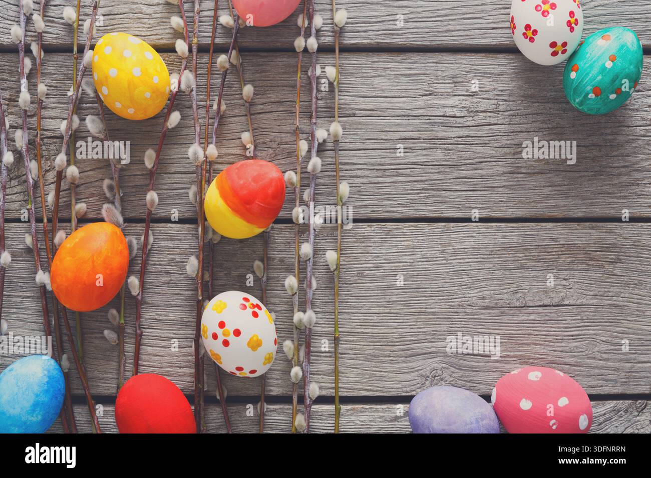Colorful Easter Eggs and Spring Decorations Arranged on a Rustic Wooden Table Stock Photo