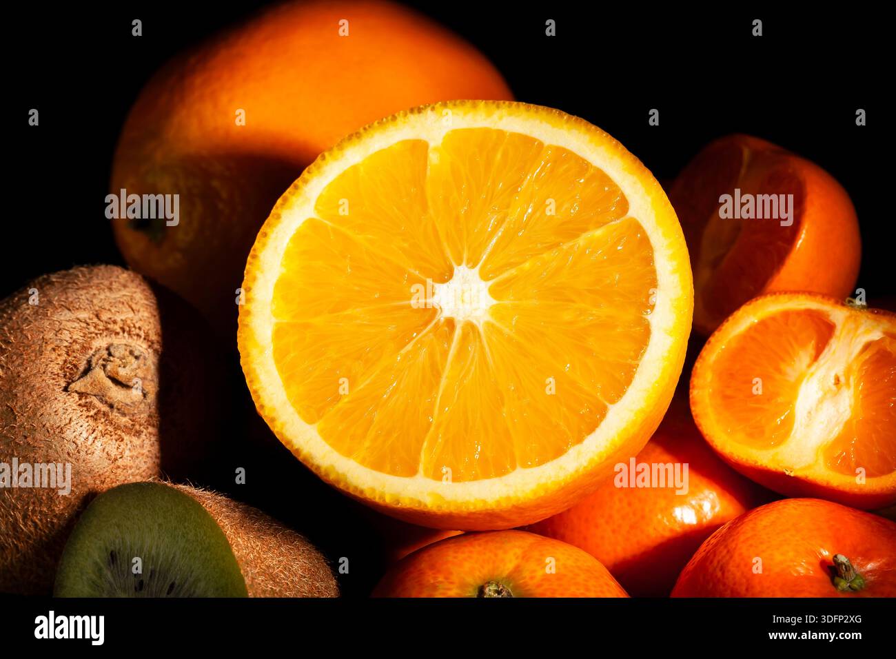 sliced orange tropical fruit mix on black background Stock Photo