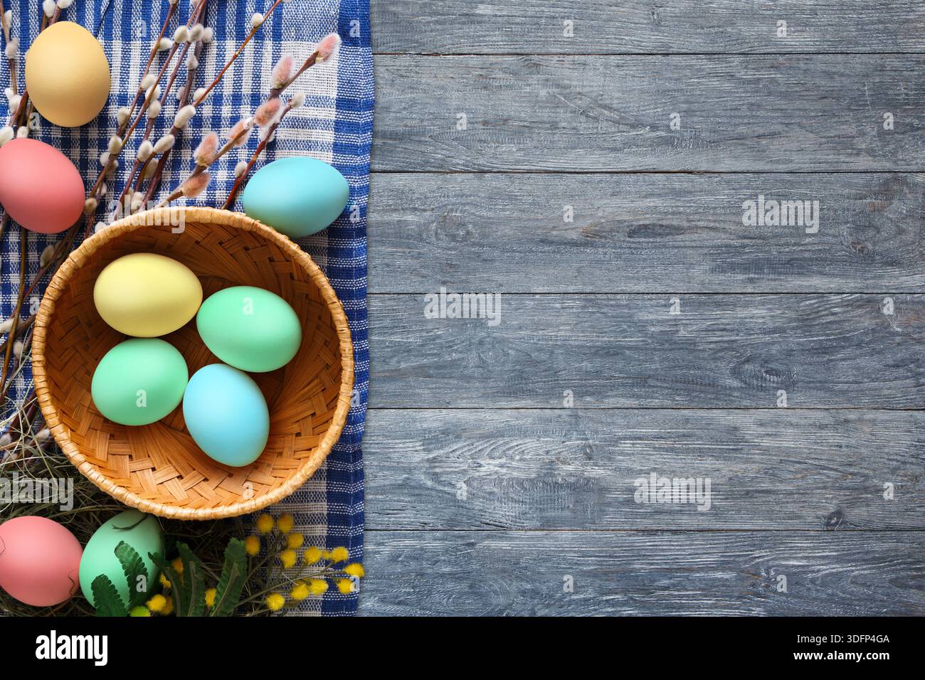 Spring Decorations Featuring Colorful Eggs and Natural Elements on Wooden Surface Stock Photo