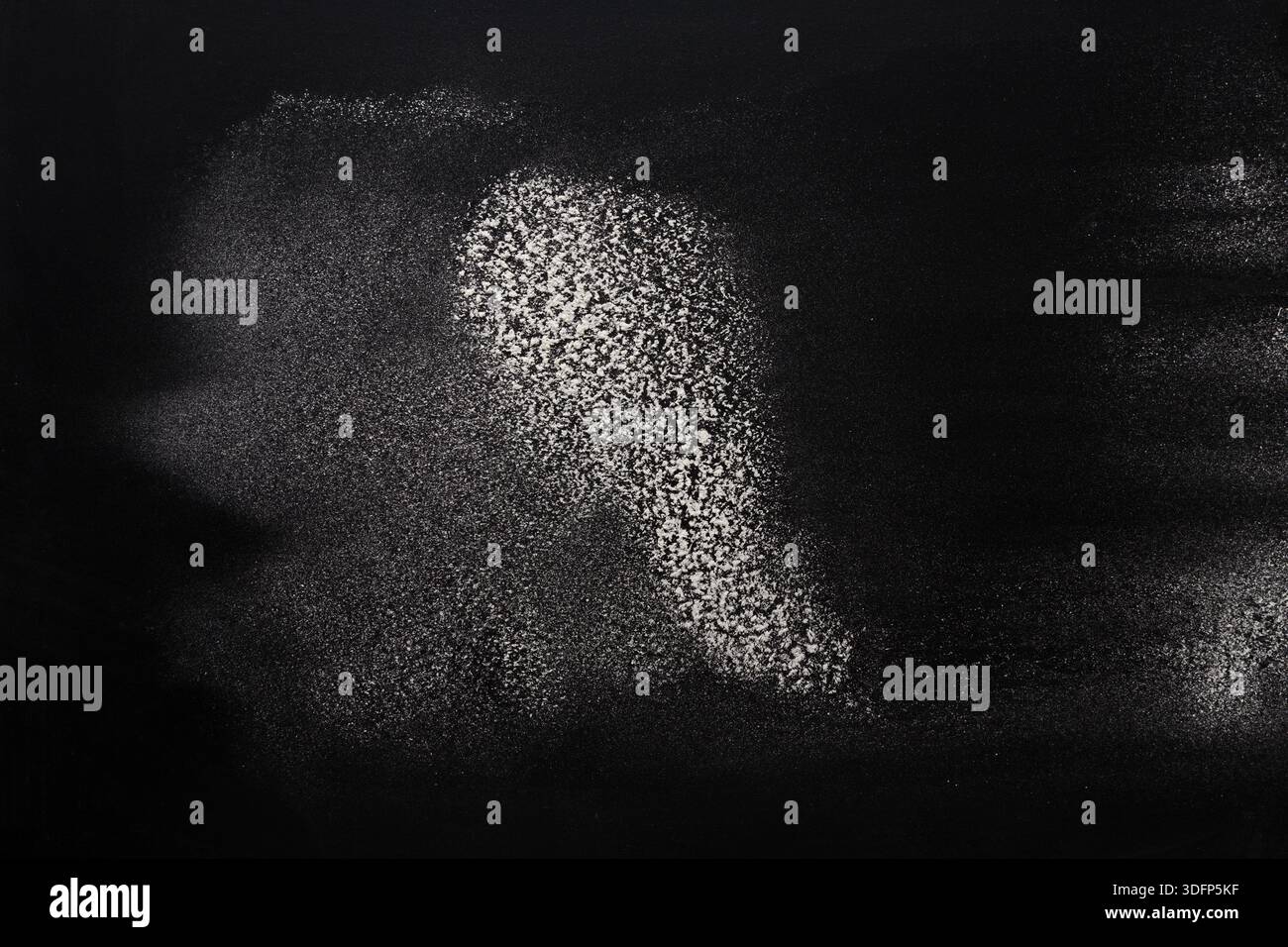 Sprinkled wheat flour splash spots on black background Stock Photo