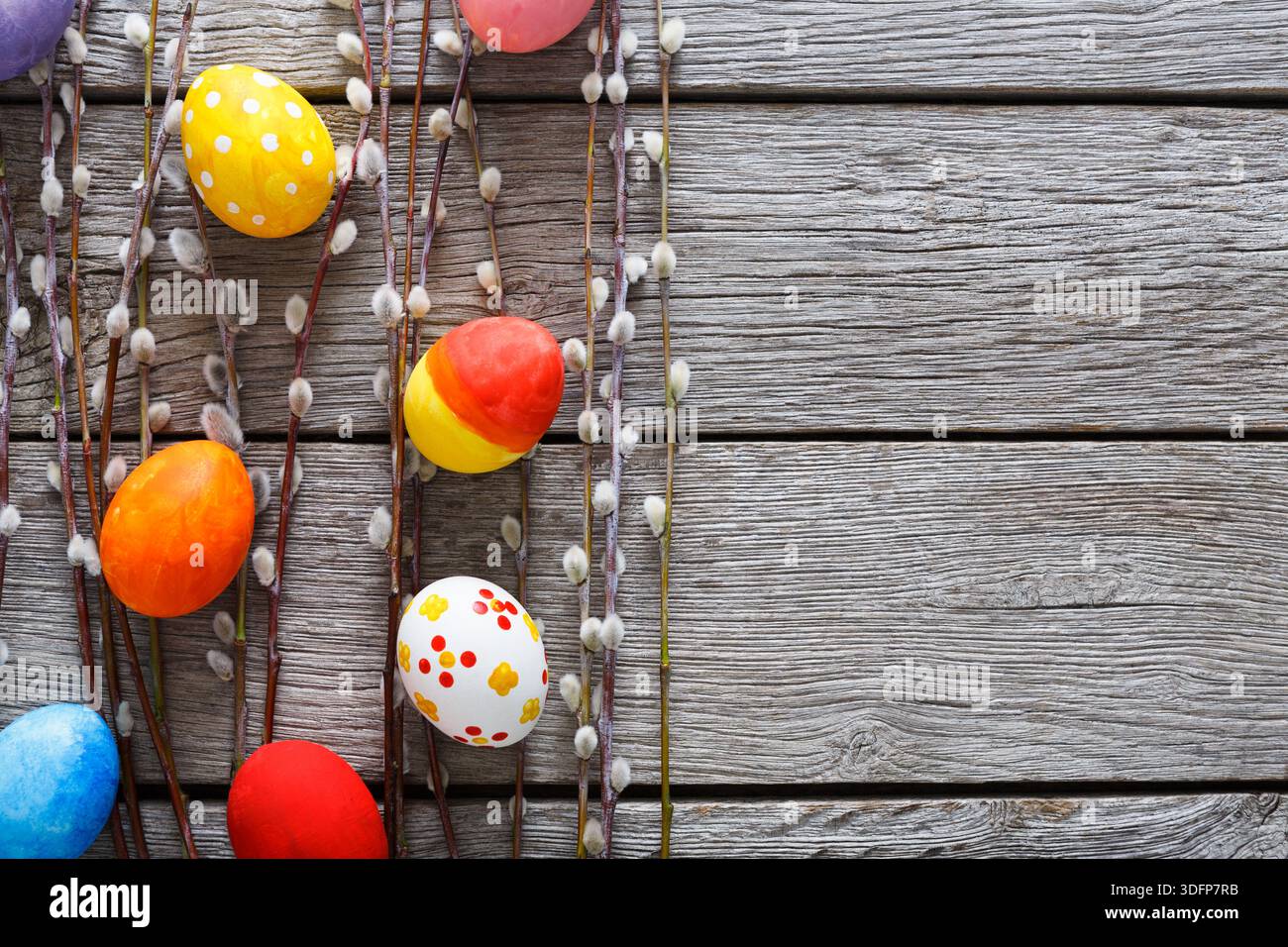 Colorful Easter Eggs Arranged on Wooden Surface With Willow Branches Decor Stock Photo