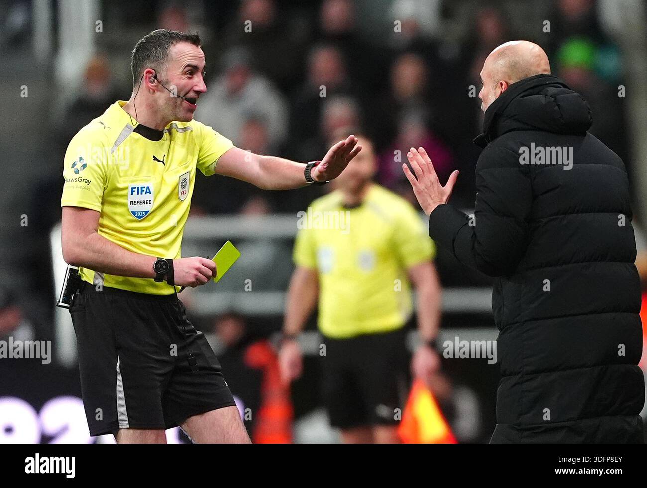 Manchester City manager Pep Guardiola (right) is shown a yellow card by ...