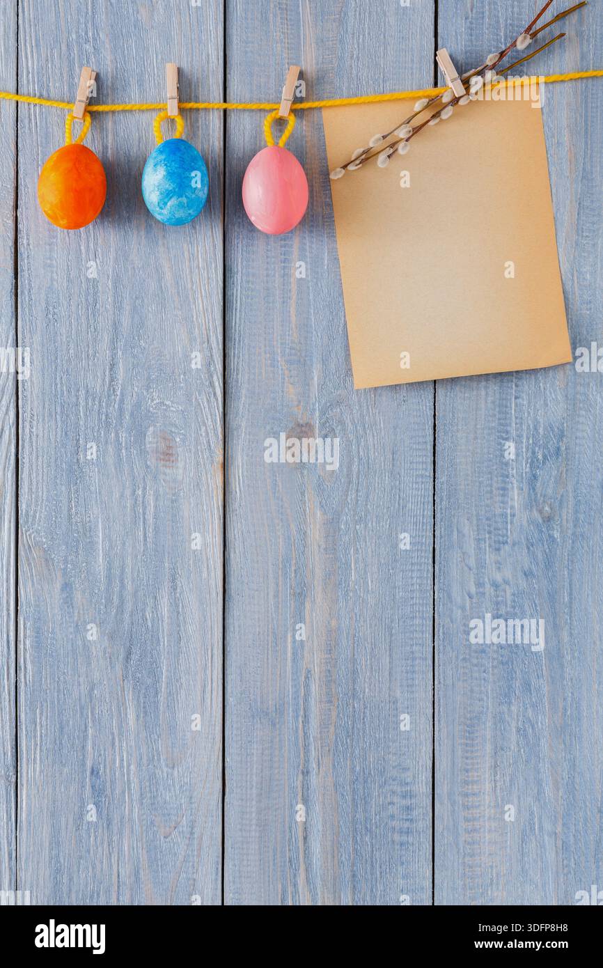 Colorful Easter Eggs Hanging on a String With a Blank Note in Springtime Setting Stock Photo