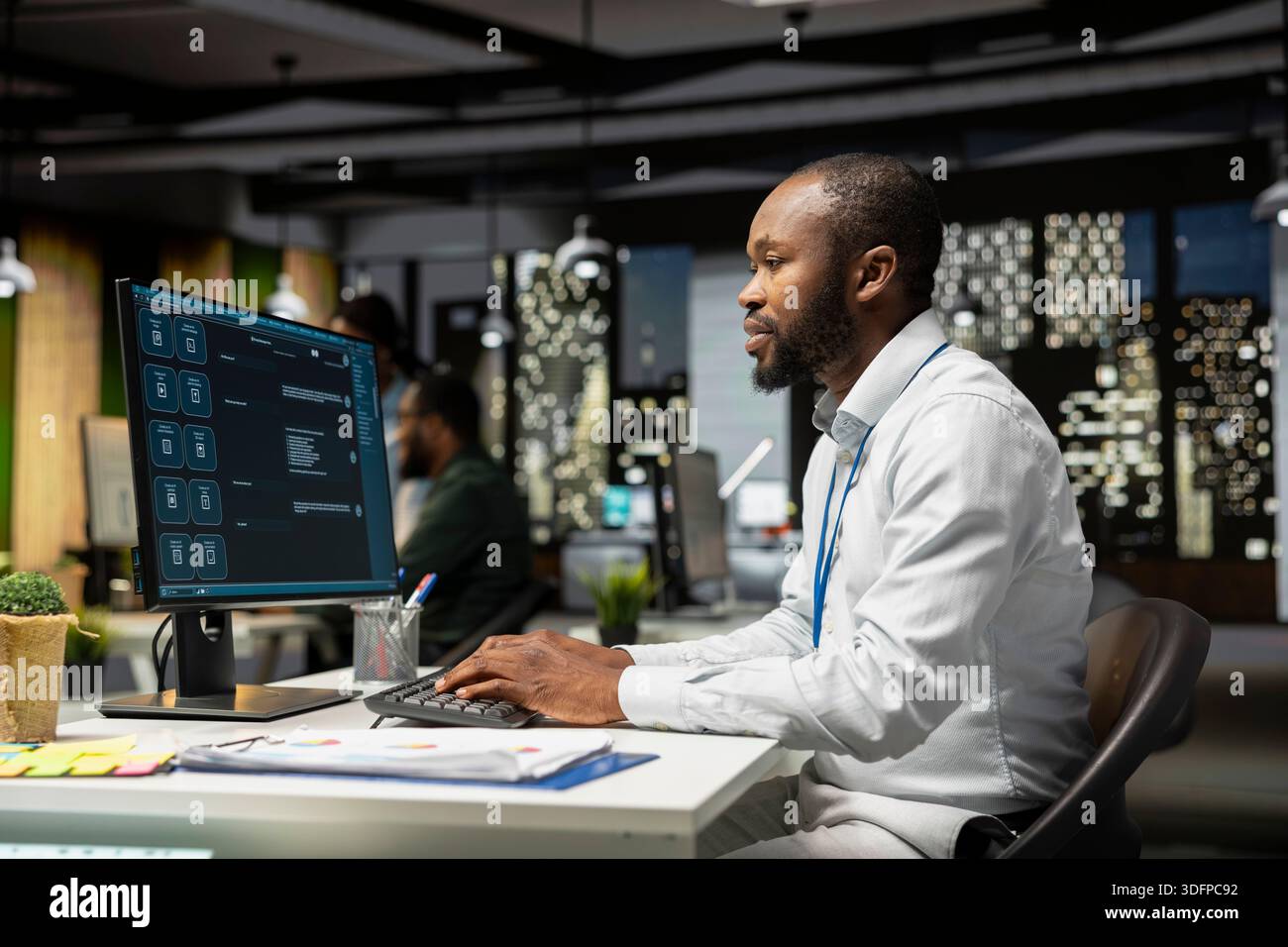 Young man programming software code on his desktop computer, using coding language for debugging tasks. Workspace with high tech helps with digital engineering and web development. Stock Photo