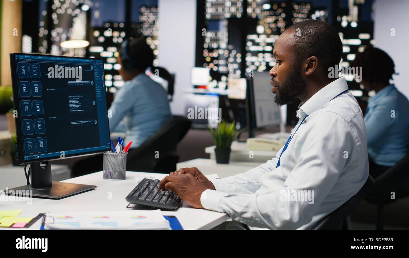 Black worker uses AI chatbot system at desktop for problem solving tasks, futuristic technology highlighting smart algorithms and machine learning. Communication and IT support. Stock Photo
