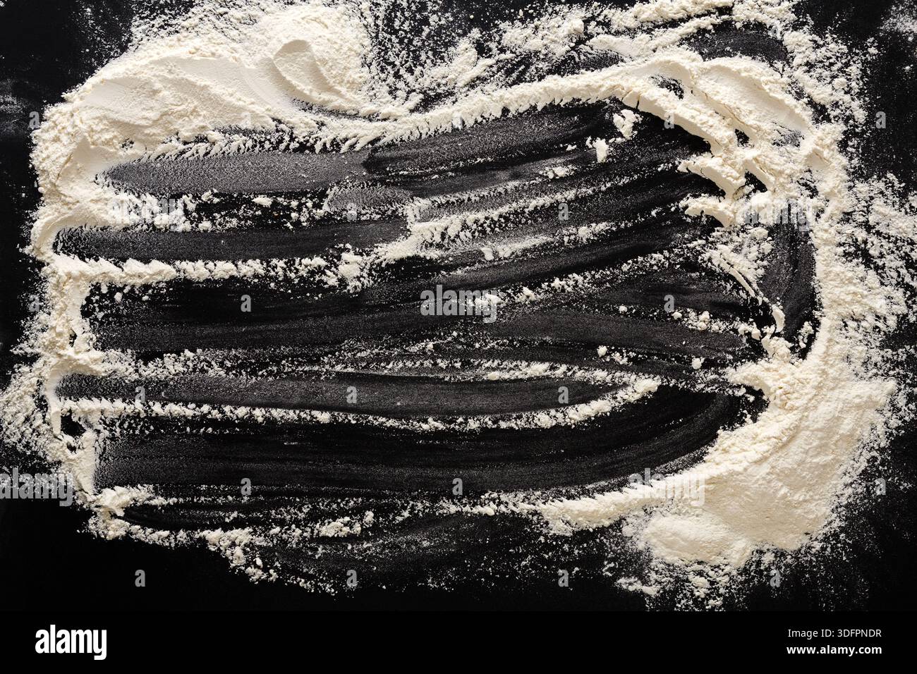 Flour Dust Creating Patterns on a Dark Surface During Baking Activity in a Kitchen Stock Photo