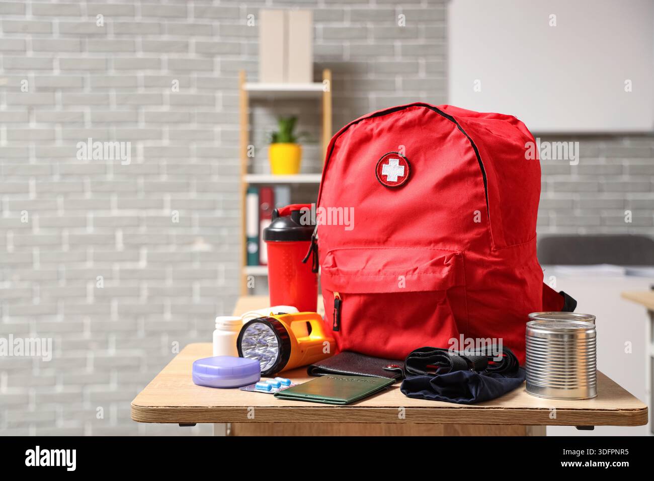 Emergency backpack with necessities on desk in classroom Stock Photo