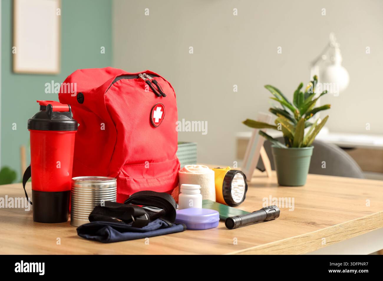 Emergency backpack with necessities on desk in classroom Stock Photo