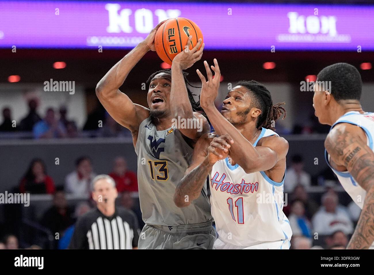 West Virginia's Chance Moore (13) drives to the basket as Houston's ...