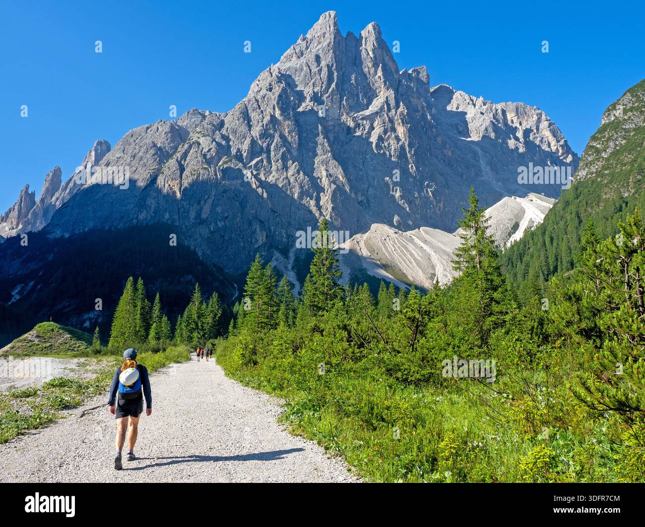 Hikers heading into the Val Fiscalina (Fiscalina Valley) with the Croda Fiscalina rising ahead Stock Photo