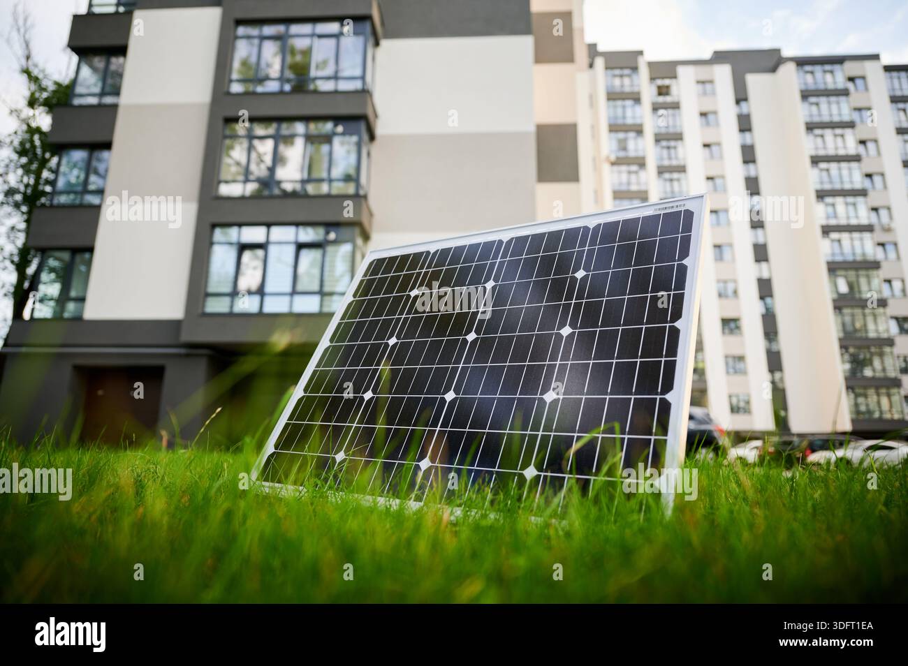 Photovoltaic solar panel in front of modern apartment building with ...