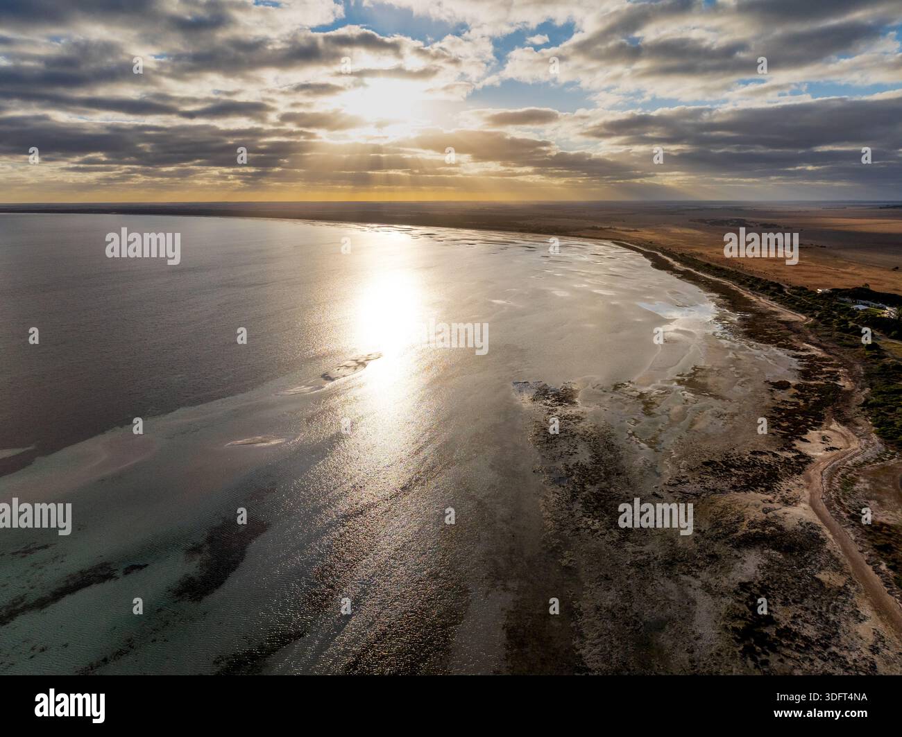Point Turton Aerial view of sunrise over a calm ocean bay alongside dry farmland at ...