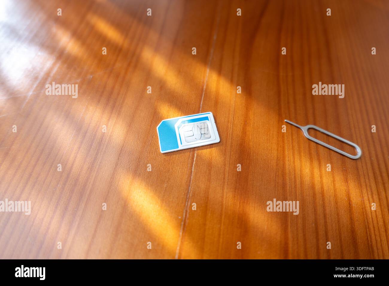 Sim Card and Eject Pin. sim card on desk, close-up Stock Photo