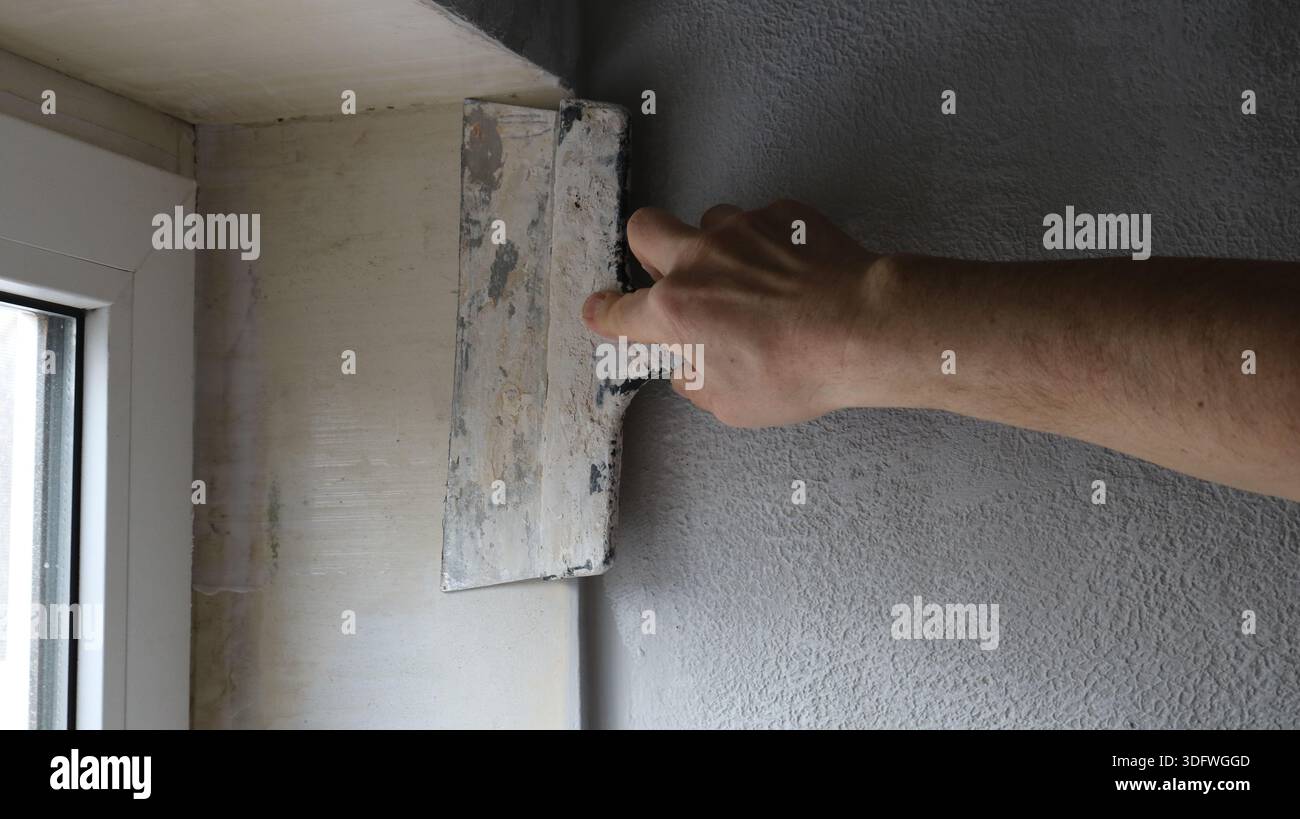 Slope Troweling A hand with a wide trowel is leveling the surface of the slope of a ...