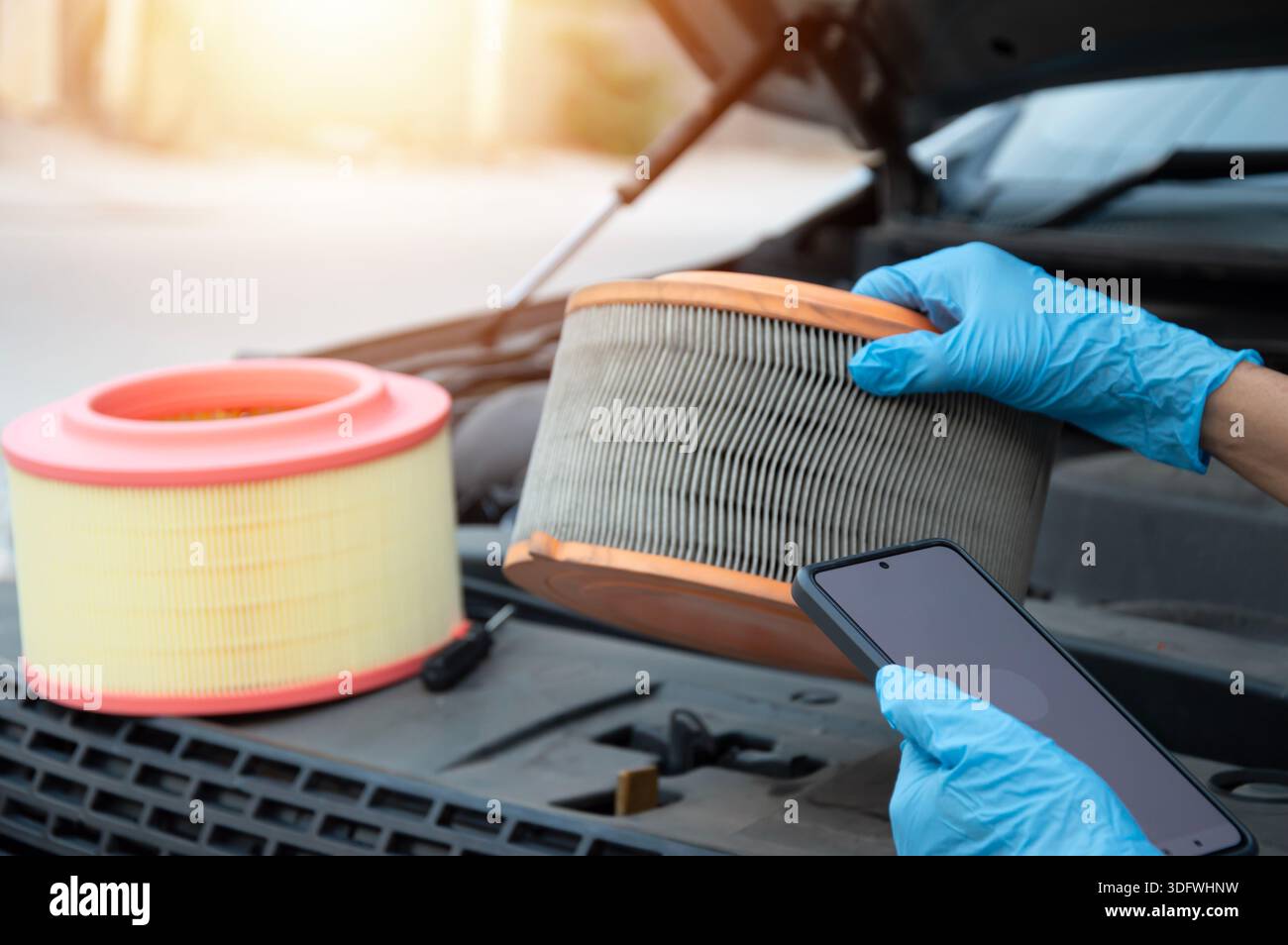 The mechanic is inspecting the old engine air filter. Stock Photo