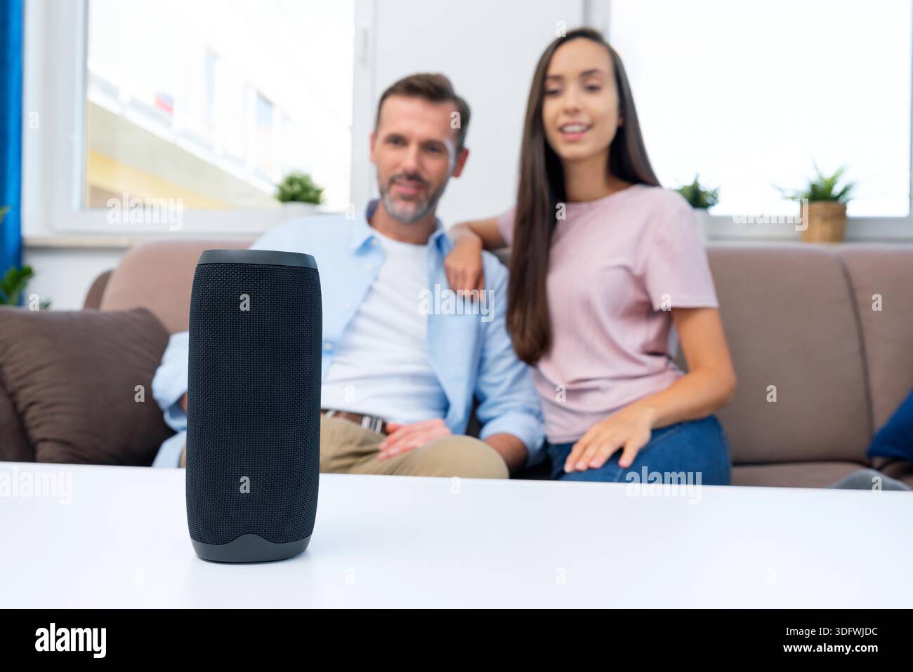 Couple using smart speaker, smart home system appliance, modern assistant || Model released Stock Photo