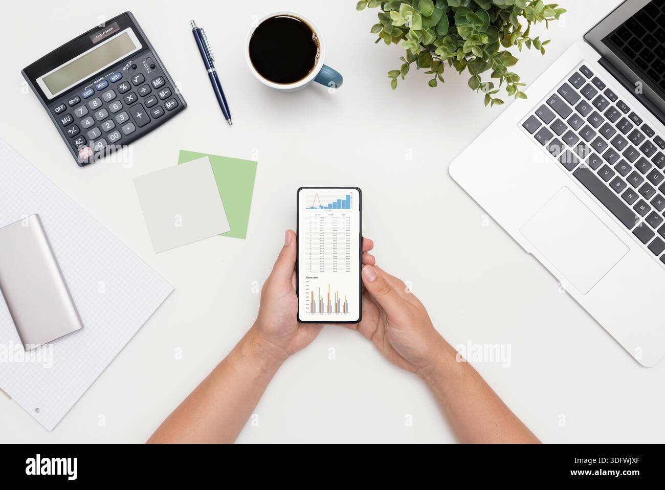 Analyst works with the data. Graphs on the smart phone screen, flat lay composition Stock Photo