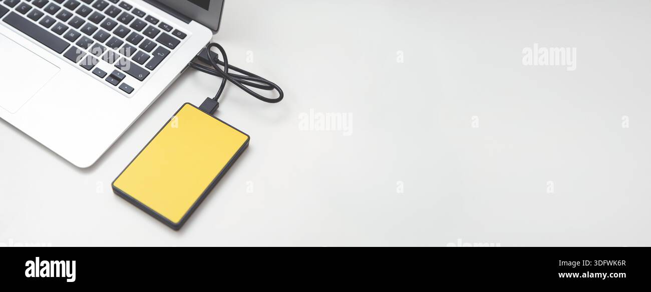 External backup disk hard drive connected to laptop. hard drive backup disk external computer data usb concept Stock Photo