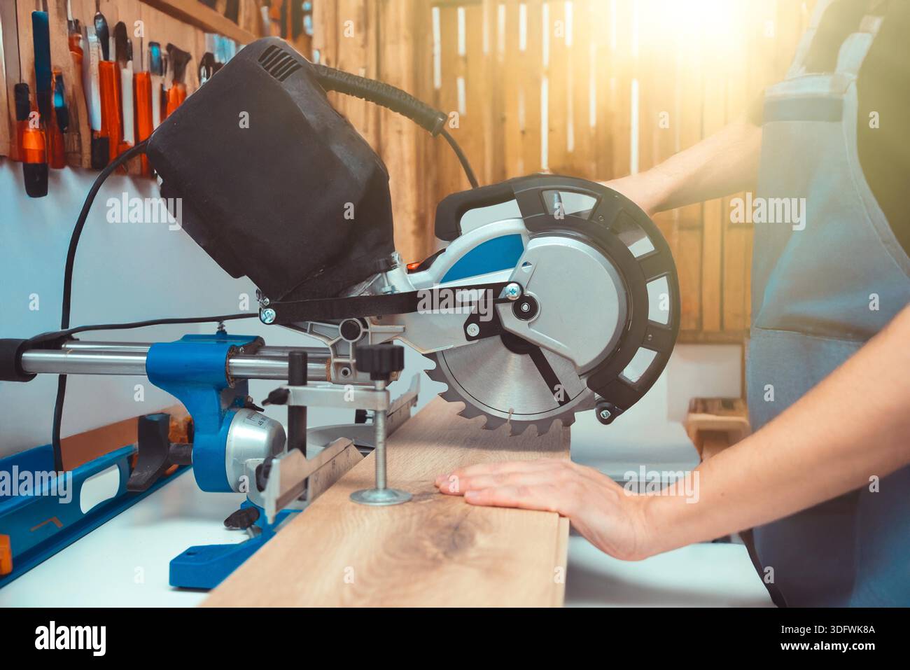 Carpenter using miter saw while working on flooring panels Stock Photo