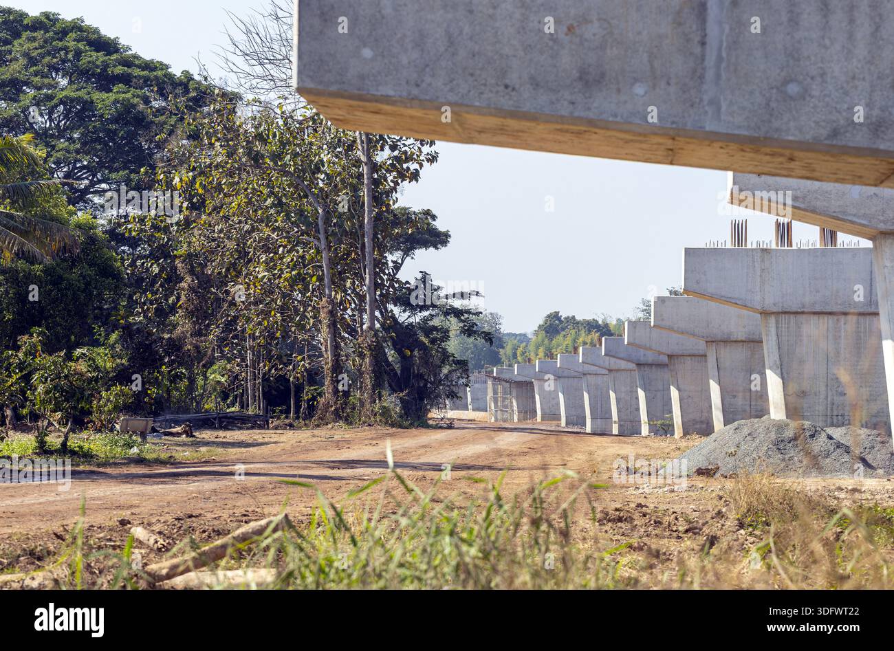 Concrete bridge structure under construction amid trees, showcasing ...