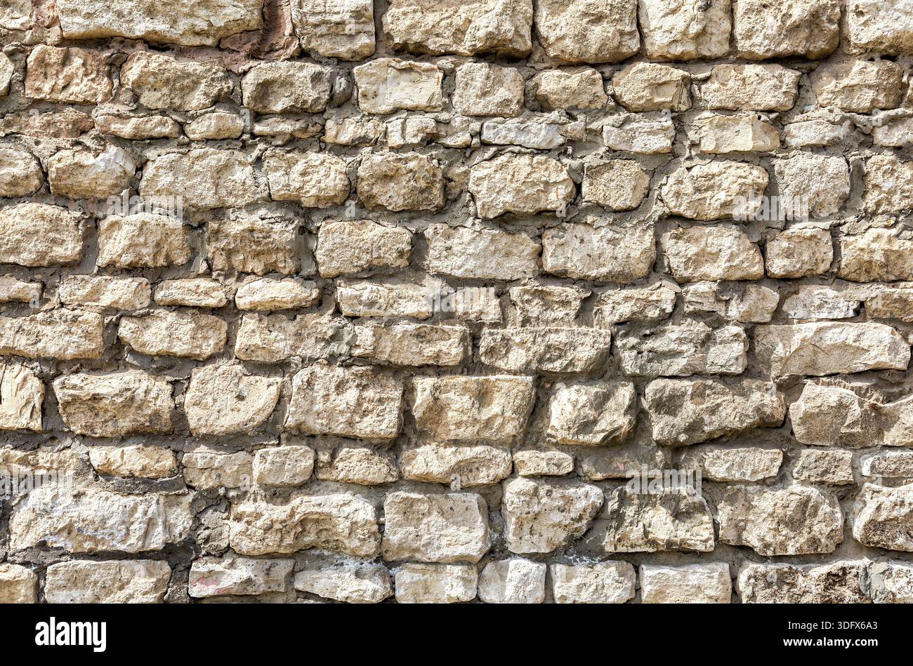 Weathered grey stone wall as creative background texture Stock Photo