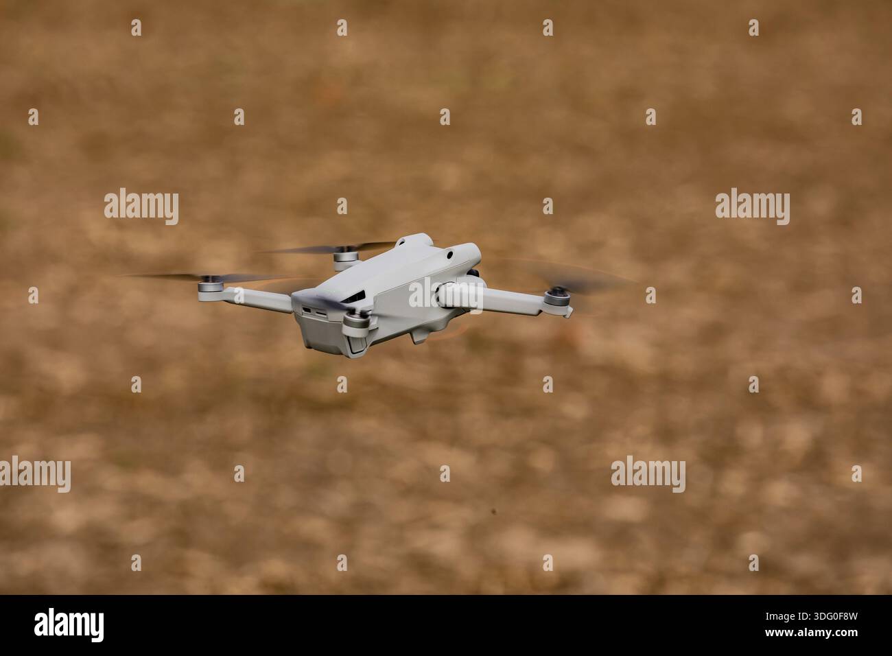 A camera drone or multicopter flying exempted over a field Stock Photo