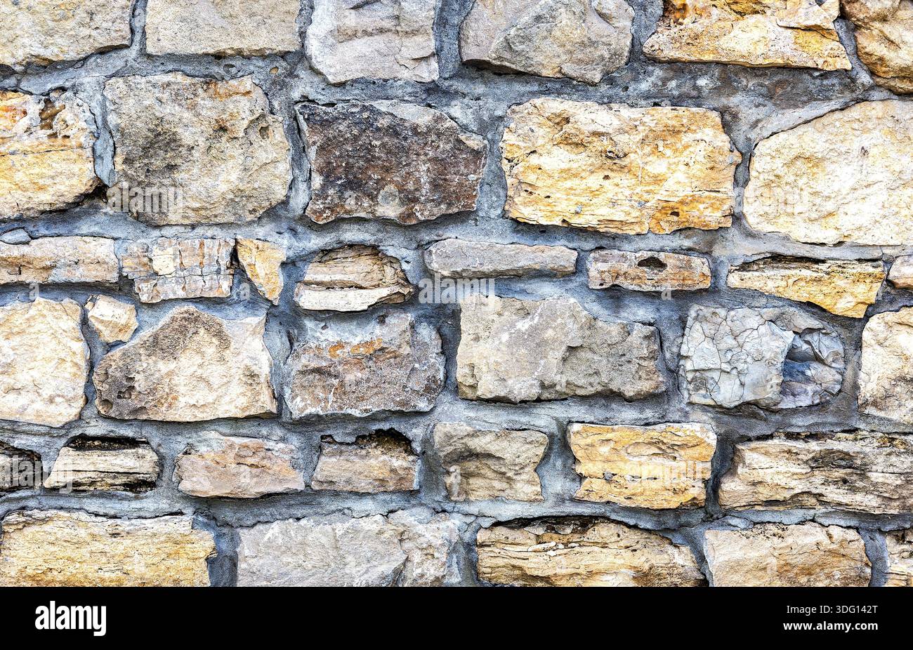 Weathered grey stone wall as creative background texture Stock Photo