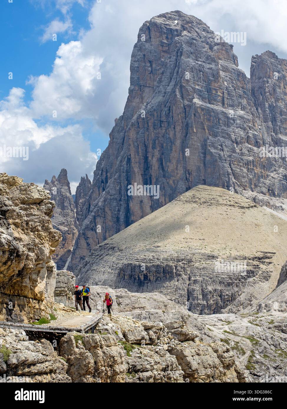 Hikers on a trail beneath the Croda dei Toni peak Stock Photo