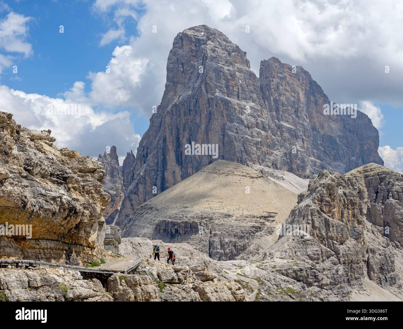 Hikers on a trail beneath the Croda dei Toni peak Stock Photo