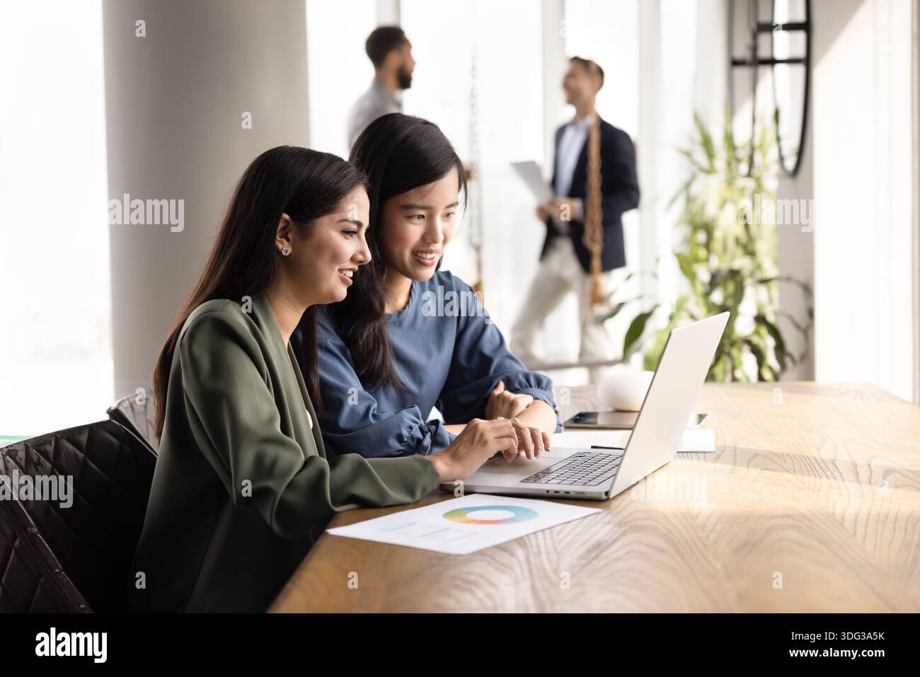 Two positive diverse female colleagues working together Stock Photo