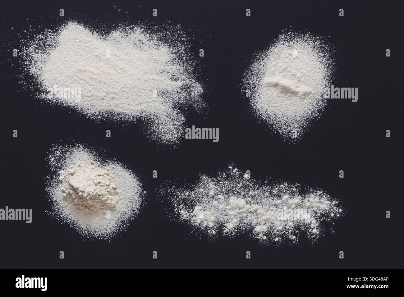 Sprinkled wheat flour splash spots on black background Stock Photo