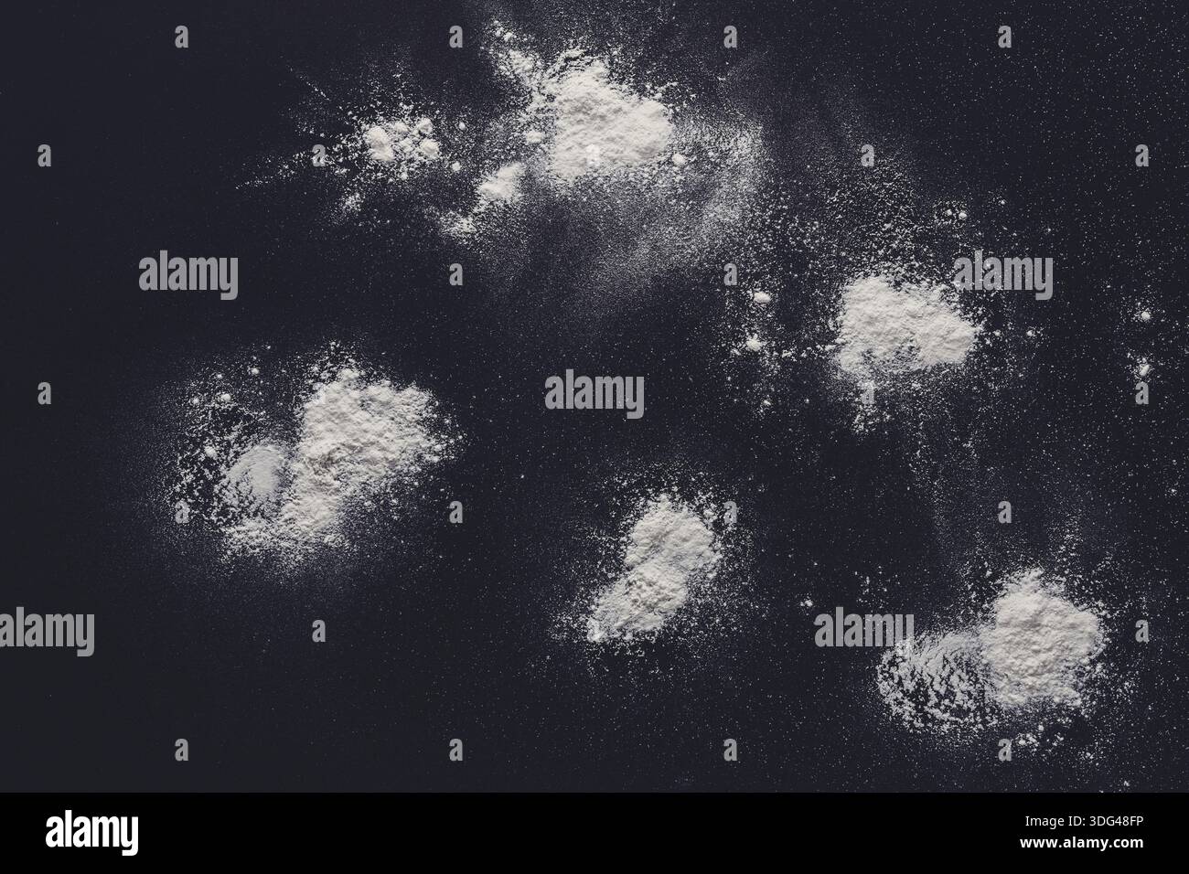 Sprinkled wheat flour splash spots on black background Stock Photo
