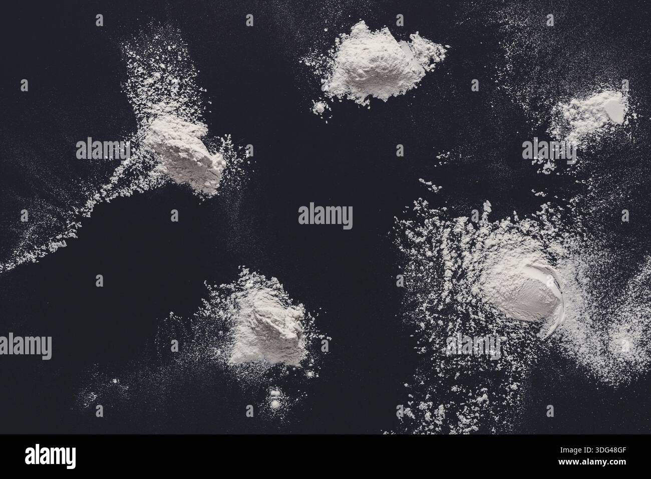 Sprinkled wheat flour splash spots on black background Stock Photo